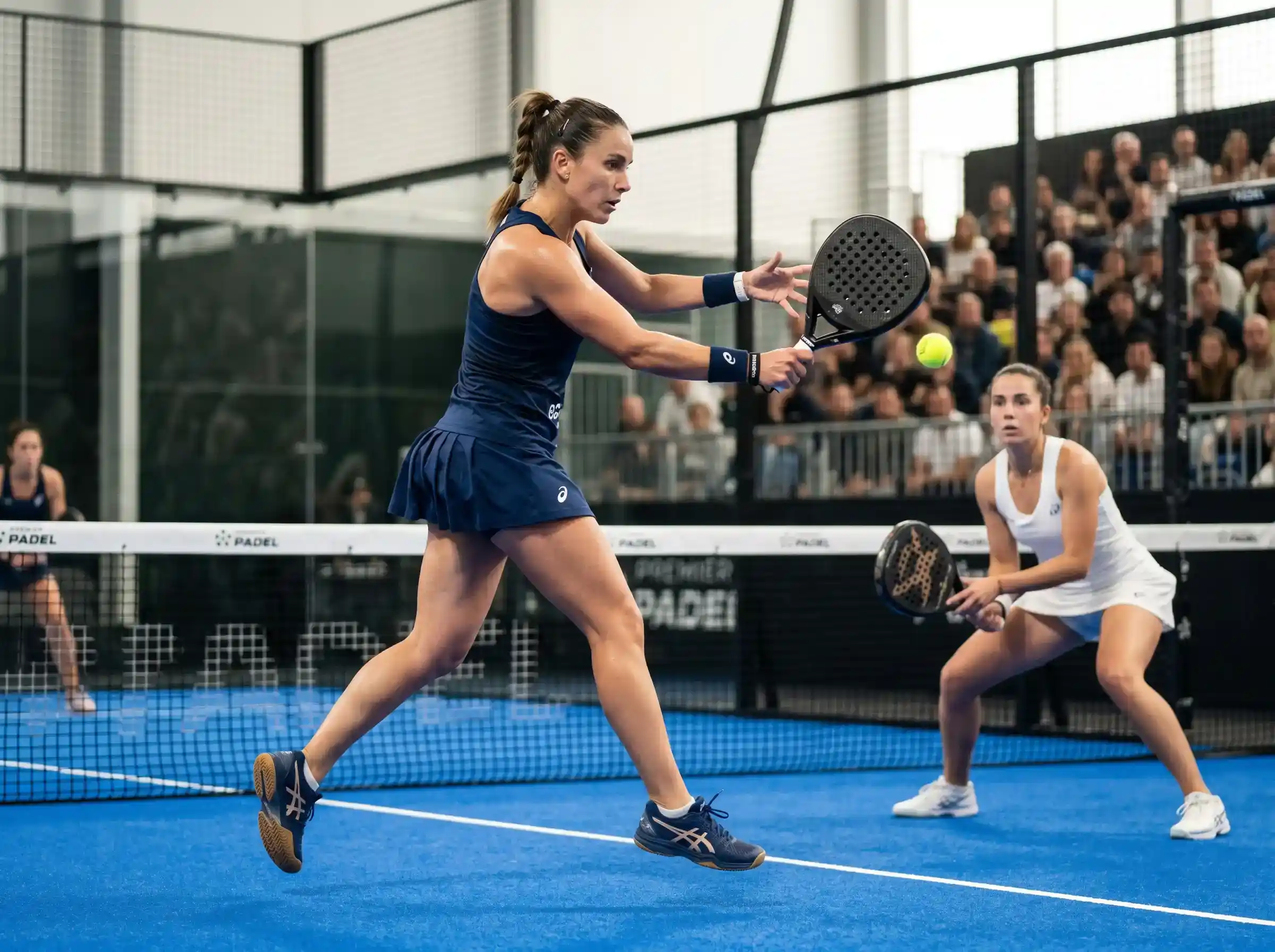 Pareja femenina profesional en acción durante un partido del cuadro femenino del circuito Premier Padel